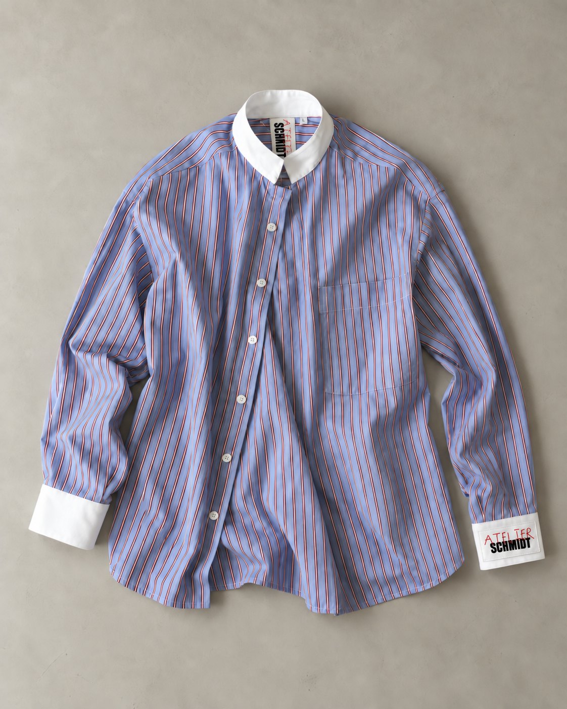 Atelier Schmidt shirt lying flat: blue striped oversized shirt with white collar and cuffs